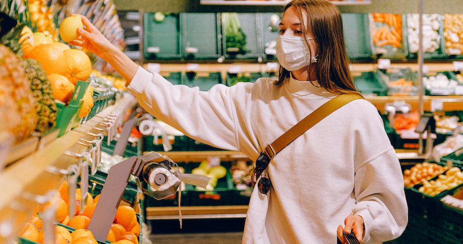 Woman wearing a mask shopping for produce, Mental Wellness in Tough Times