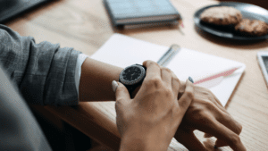 Woman checking time on her watch, mindful of time management mistakes.