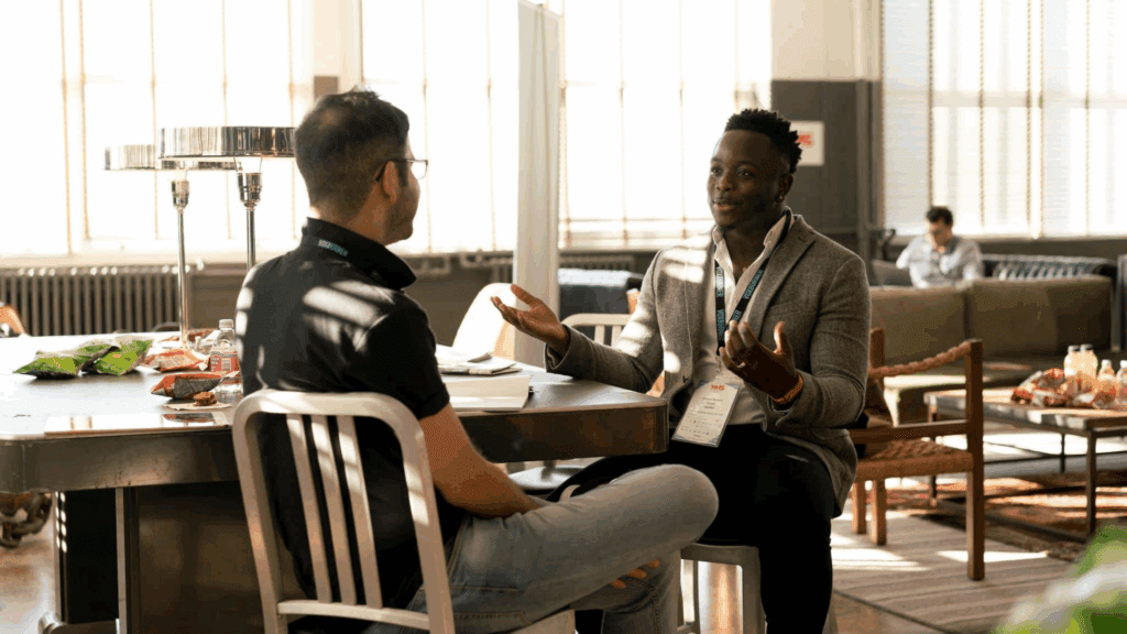 Two men engaged in a respectful discussion, demonstrating assertive communication in a professional setting.