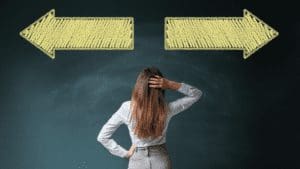 Neuroscience Updates And Neuroplasticity Woman looking at blackboard with arrows going in opposite directions and scratching her head about how to make a confitent decision