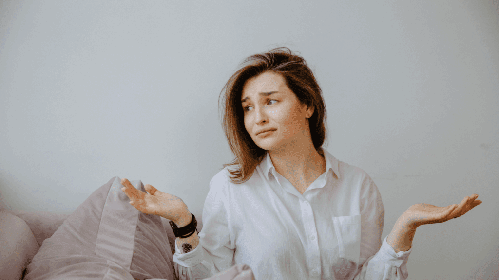 Woman in a white shirt shrugging with an uncertain expression, representing the need for brain-based strategies.
