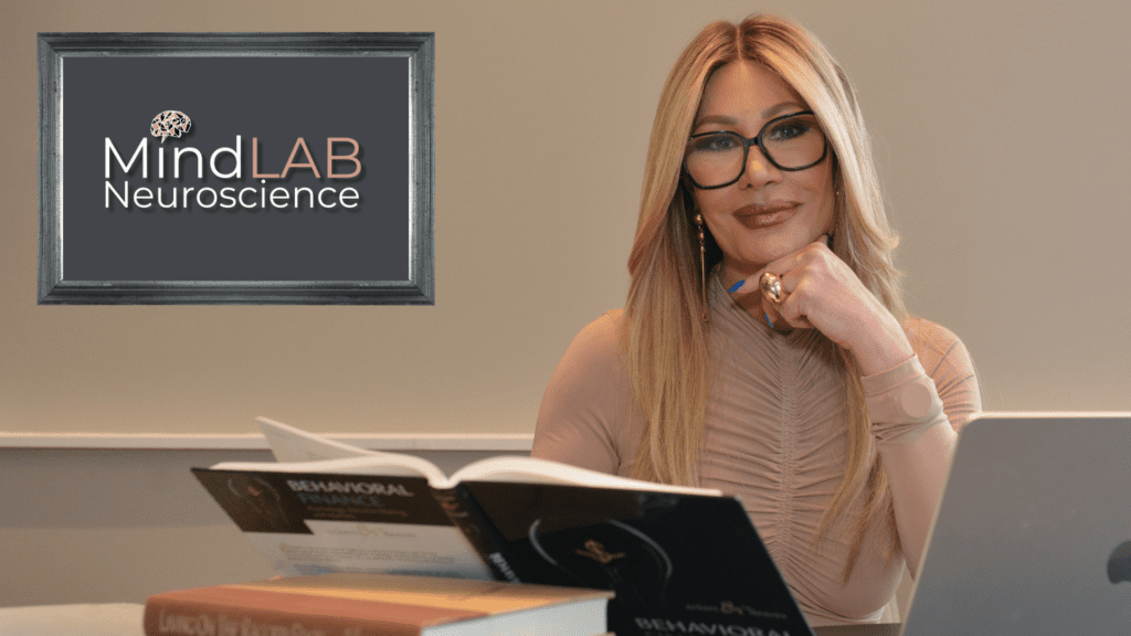 Dr. Sydney Ceruto smiling at camera while studying at her desk for her Life Coaching Program.