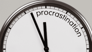 Clock pointing to 'procrastination', symbolizing overcoming procrastination through life coaching for achieving goals and behavior change.