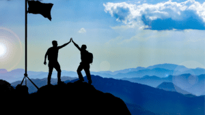 "two men celebrating personal growth and goal achievement through life coaching on a mountain summit. Keywords: personal growth life coaching, enhancing self-awareness life coaching, brain-based coaching emotional health. "