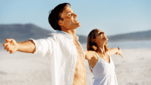 Relaxed couple on beach practicing successful stress management techniques and embracing brain-based methods for personal growth