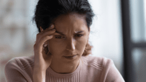 Unhappy woman seeking to overcome negativity and develop positive self-talk through life coaching and neuroscience to silence critical inner voice.