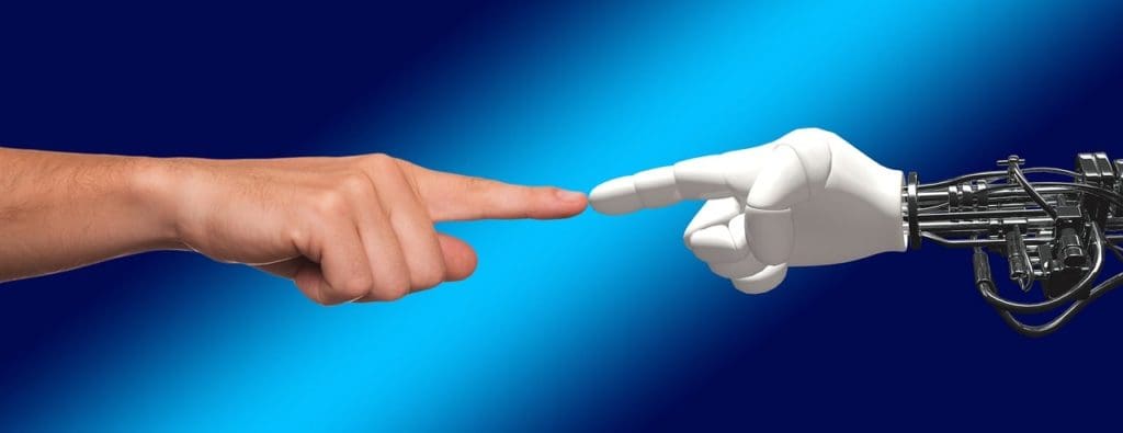 Human hand touching robot hand showing the future of artificial intelligence