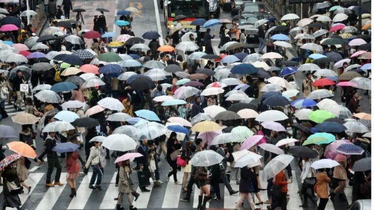 Crowd of people holding different color umbrellas, symbolizing various personality types.
