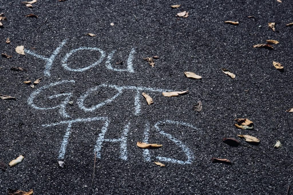 Chalk writing on asphalt saying "You got this," symbolizing overcoming Borderline Personality Disorder and splitting