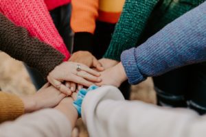 Diverse group of people with different personality types joining hands
