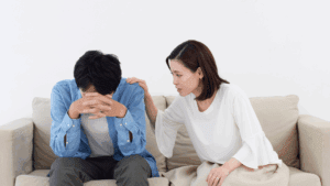 Woman comforting a man during an emotional conversation on a couch, symbolizing Embracing Vulnerability in relationships.