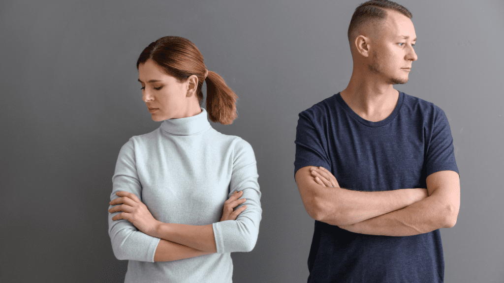 Unhappy couple with crossed arms, recognizing the need for a relationship counselor