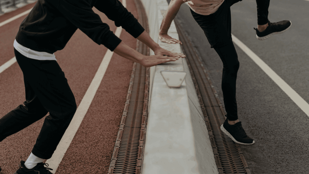 Overcoming Communication Barriers & Cognitive Biases 1 Two people stretching and jumping over a barrier, symbolizing overcoming communication barriers.