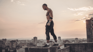 Fit man overcoming mental blocks, confidently exercising atop a nyc building.