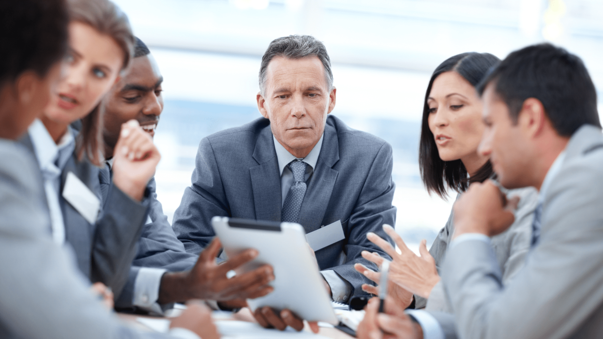 Corporate executive displaying leadership skills from a neuroscience-based executive coaching program during a team meeting.