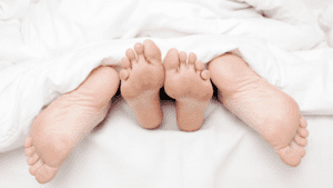 Couple's feet outside covers symbolizing Brain Chemicals During Sex