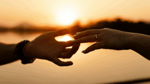 Understanding the Role of Neuroscience in Love Biases 1 Two hands reaching for each other at sunset, symbolizing connection and the role of neuroscience in love biases.