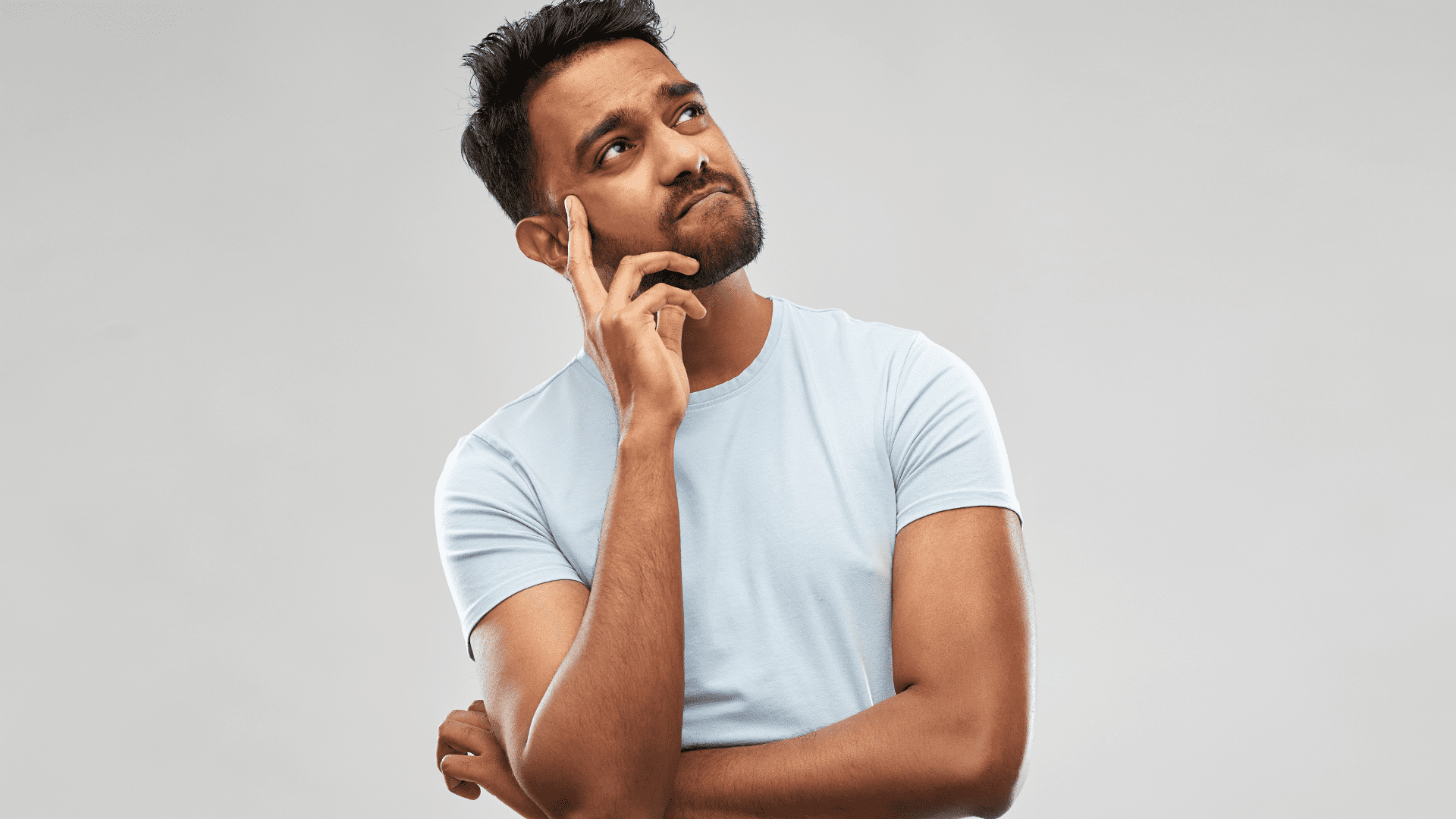 a man with a beard and mustache in a white shirt thinking