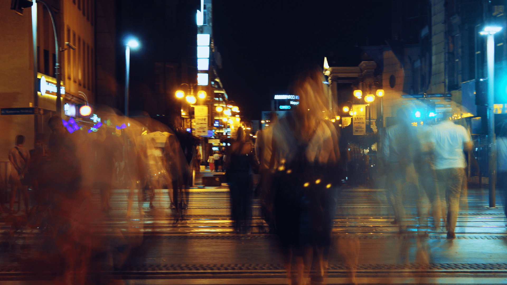 a blurry picture of a group of people walking on a street at night