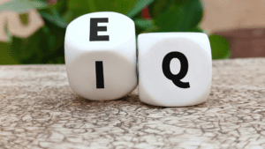 EQ and IQ symbols on dice highlighting emotional intelligence contrast