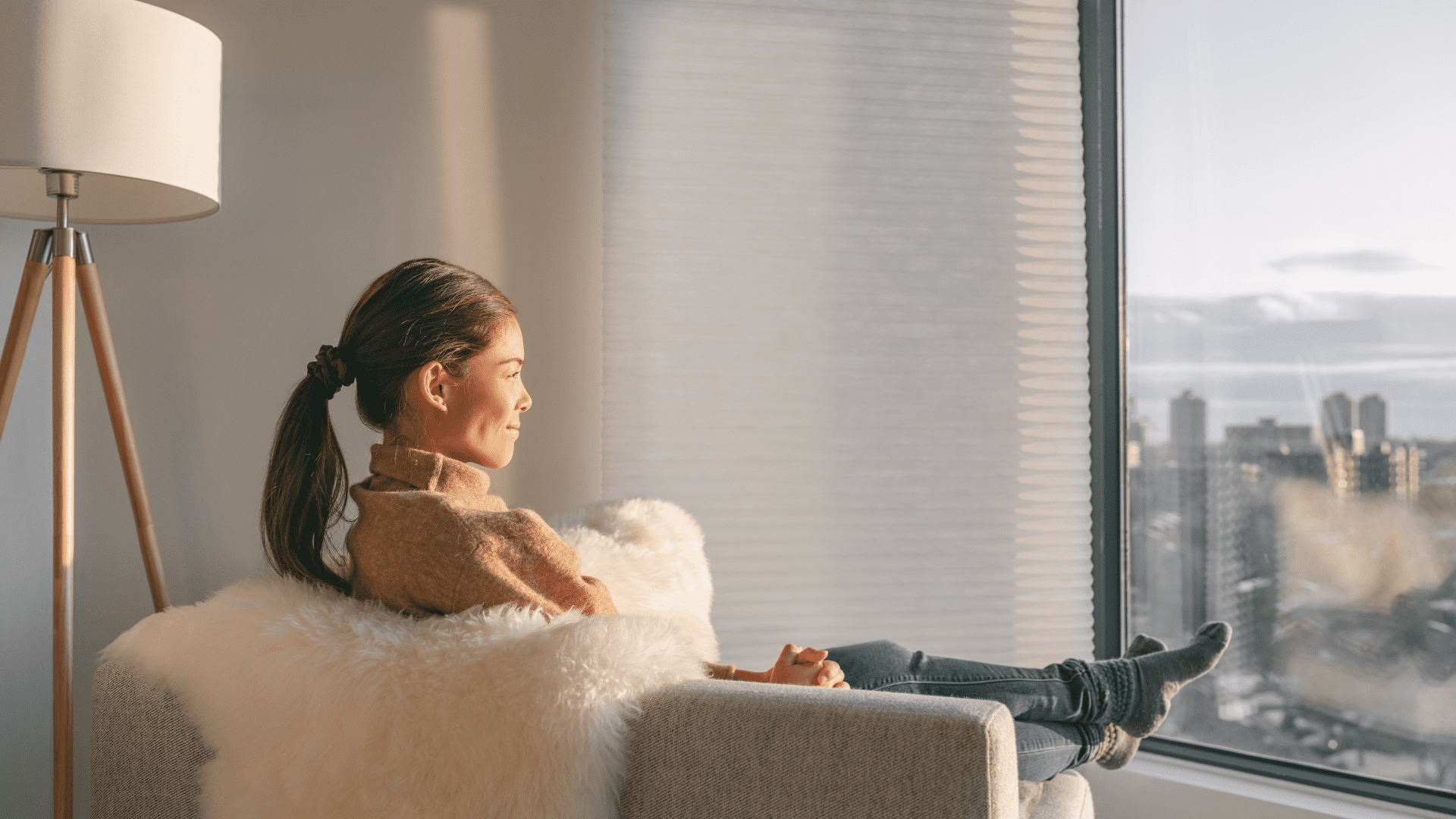 Young woman smiling out of window reflecting neuroplasticity and mental wellness journey.