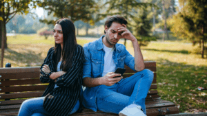 Couple in argument influenced by Critical Inner Voice and Relationships on park bench