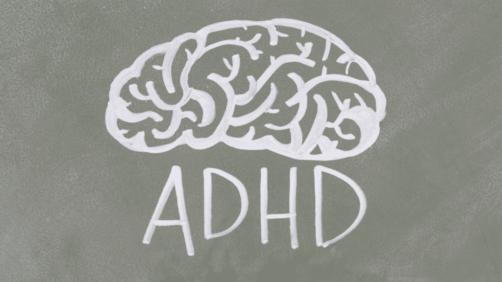 A white brain drawn on a grey surface spelling out adhd