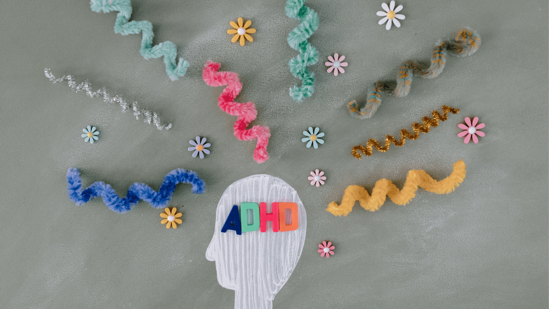 a paper cut out of a head with colorful curly ribbons and flowers