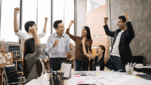 A group of people celebrating in a room after their deep work habits proved to be a great accomplishment