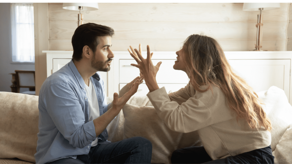 a man and woman sitting on a couch arguing having no emotional control