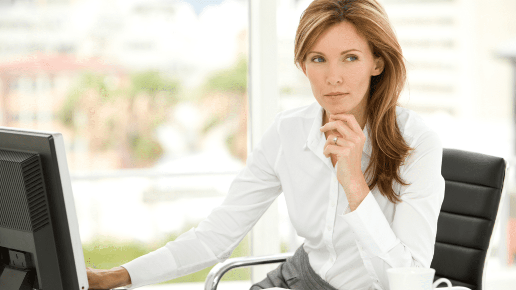 a professional business woman sitting at her desk who has received neuroscience-based executive development 