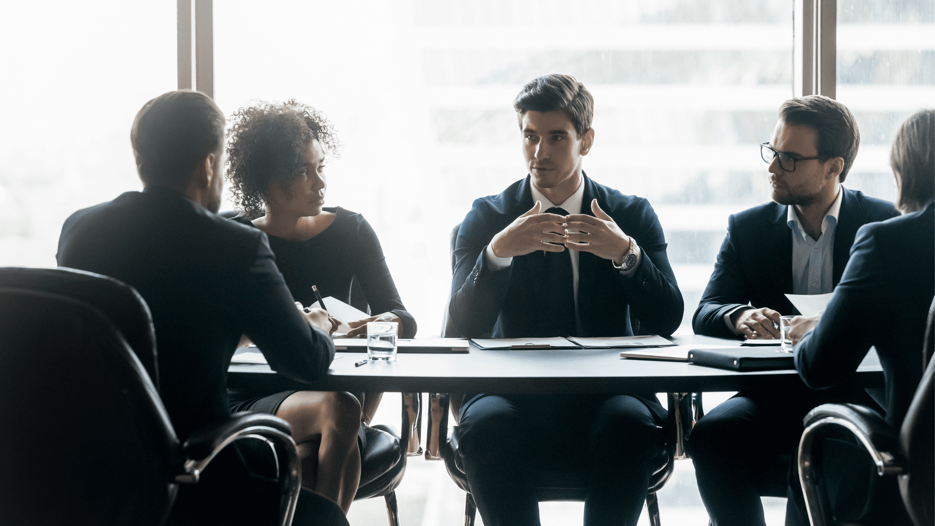 group of executive professionals at a confernce table who have learned neuroscience-based executive development