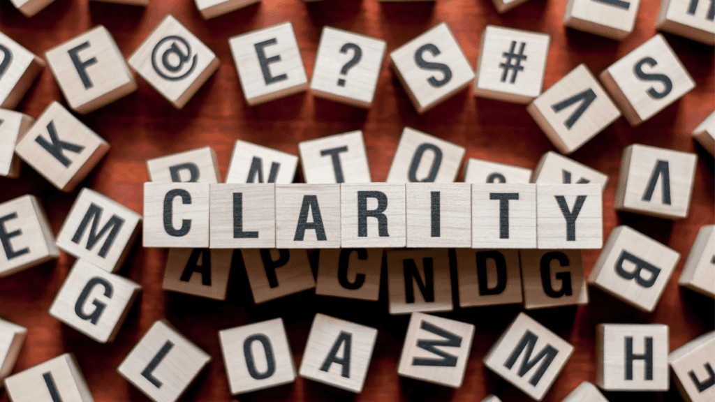 Wooden blocks spelling out "Clarity" among scattered letters, symbolizing mental clarity.