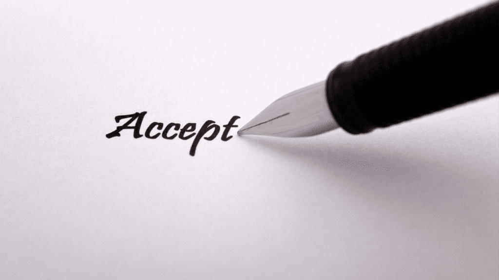 A pen writing on a piece of paper spelling the word accept indicating the power of radical acceptance.