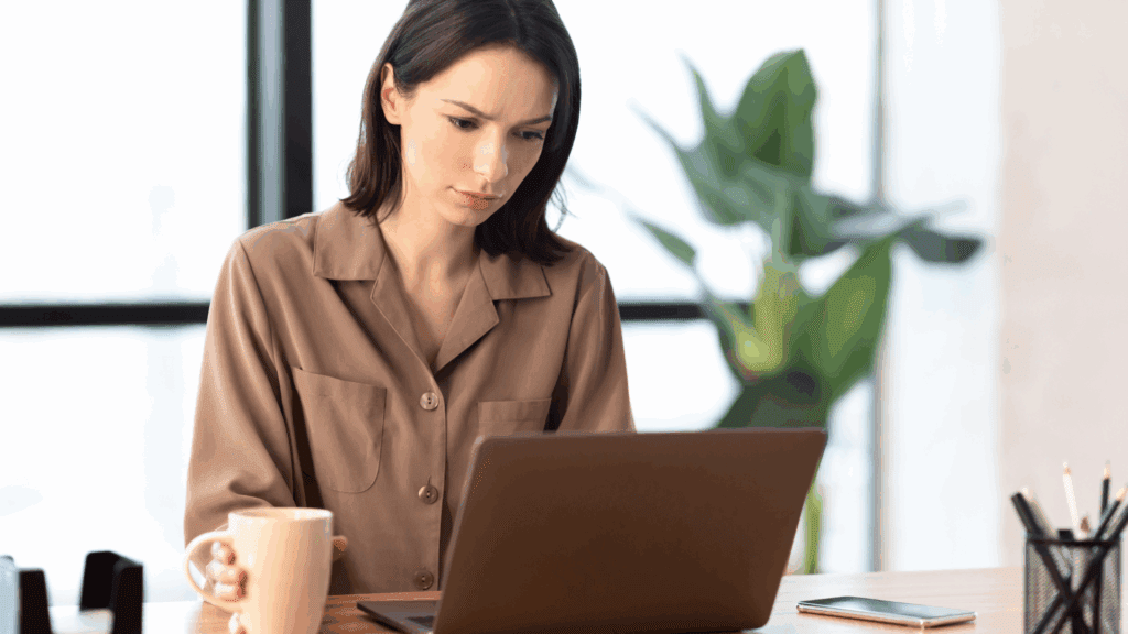The Transformative Power of Generative AI: 7 Ways It’s Revolutionizing Mental Health 2 Woman working on a laptop researching Generative AI while holding a coffee mug.