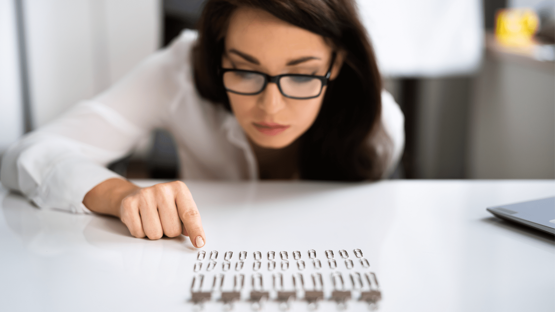 a woman pointing at a row of paper clips