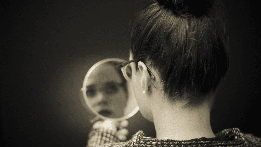 a woman looking at her reflection in a mirror looking to find a core identity