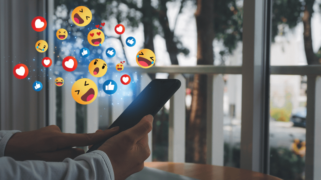 Emojis popping up from a phone describing the role social media has on the mental health among gen-z and millennials