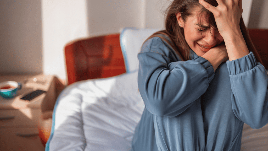 a woman in a blue shirt suffering from anxiety and worry in the modern world.