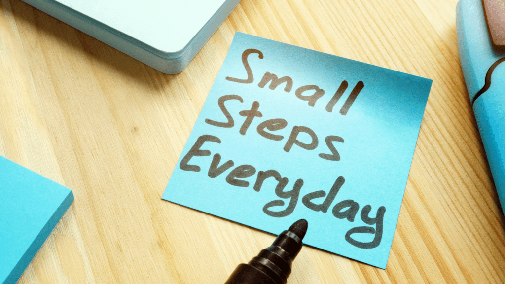 a blue note with black marker on it spelling out small steps everyday to stay motivated to be successful at reaching your goals