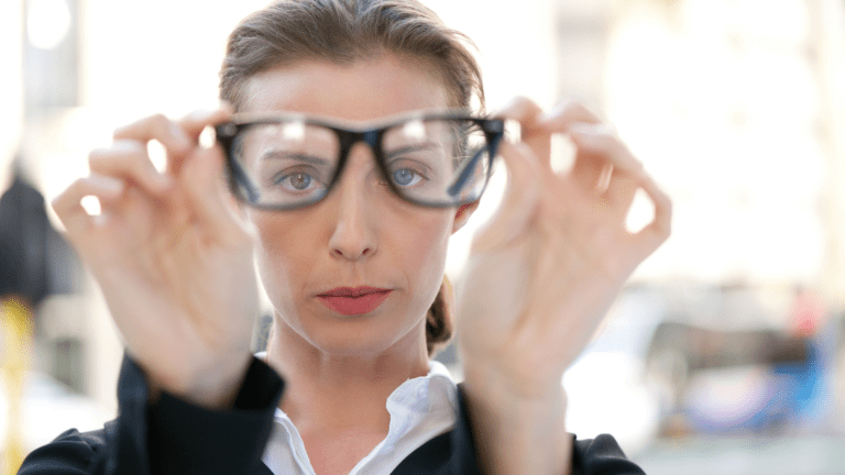 Woman adjusting her glasses, focusing on changing perspective.