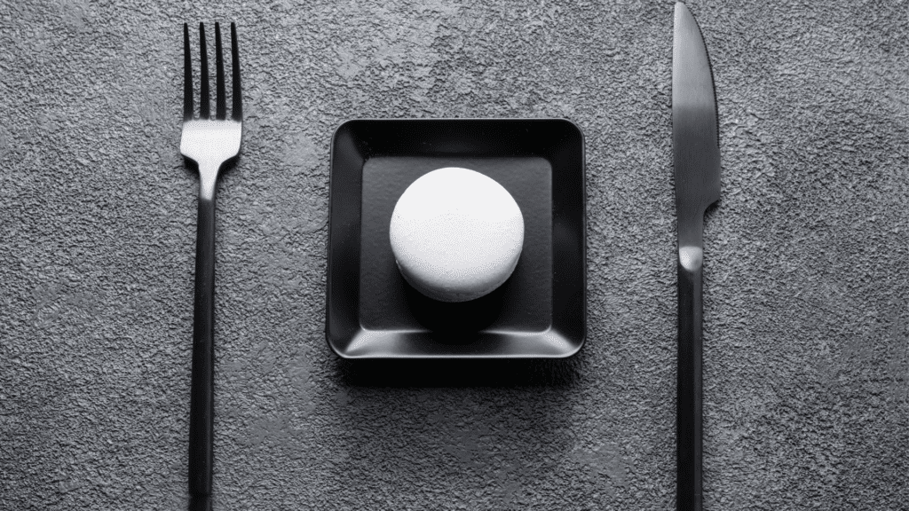 Perfectionism in dining setup with a single macaroon.