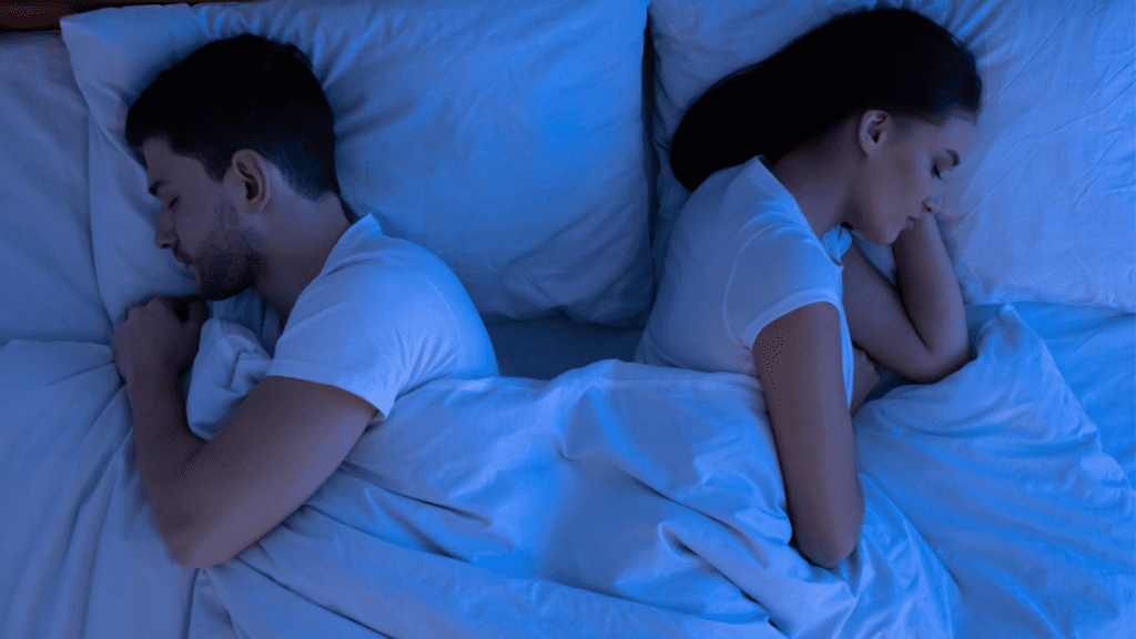 A couple sleeping back-to-back, illustrating a sexless marriage. 
