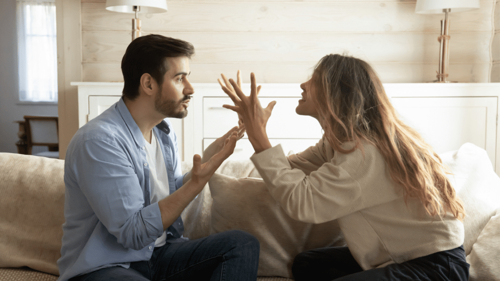 A couple engaging in a heated confrontation in their living room.
 