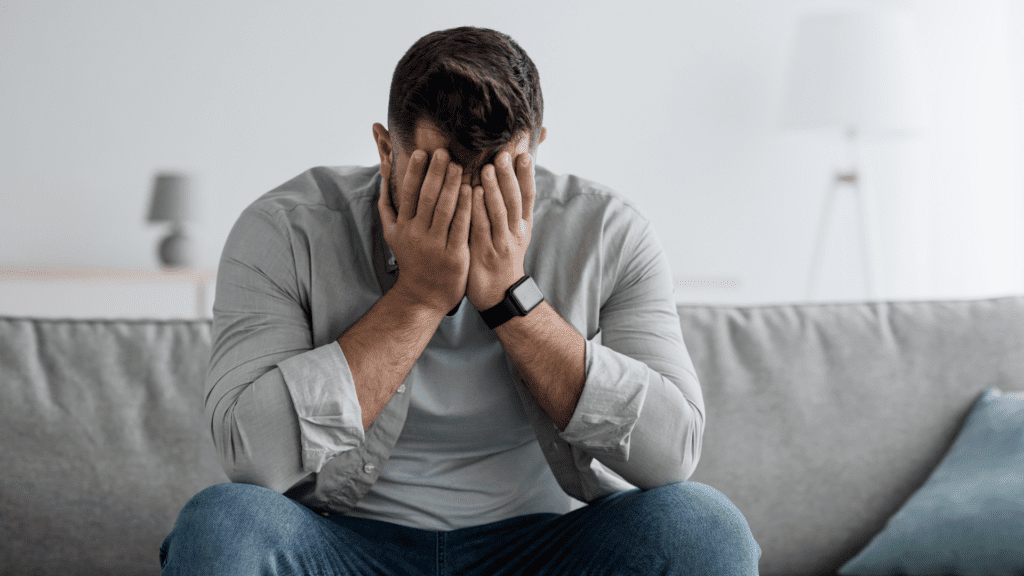 Person holding their head in their hands, representing mental health struggles
