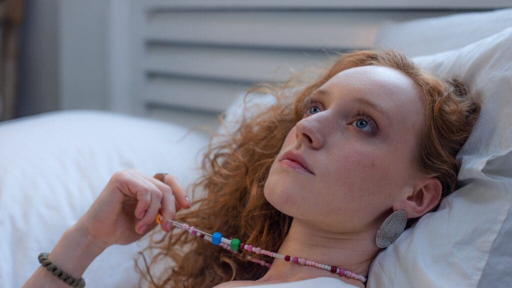 Woman lying in bed, staring upward, representing overthinking and emotional stress.


