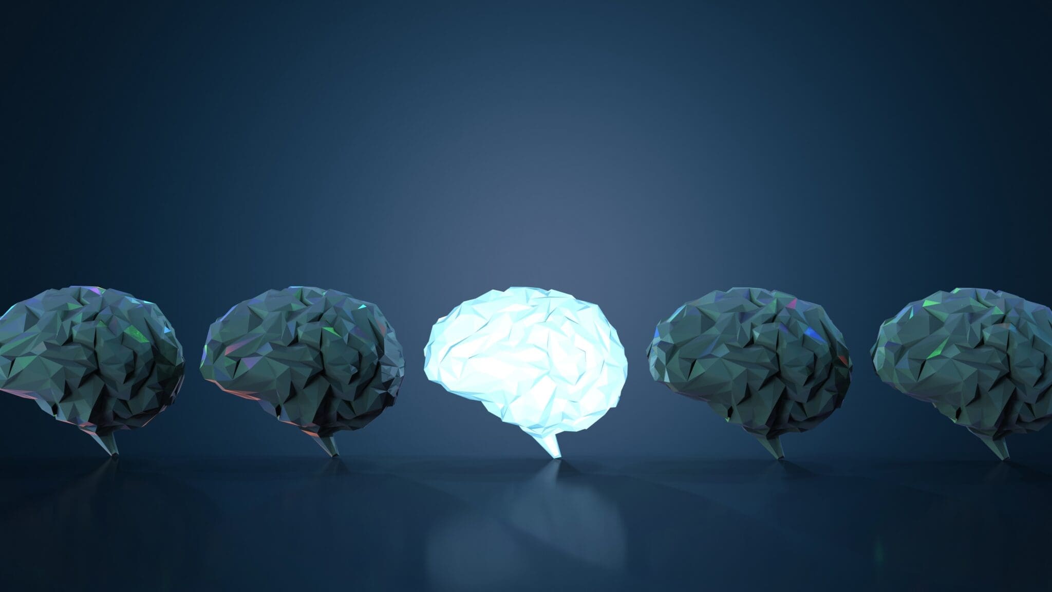 Row of brains with one brightly illuminated, symbolizing transformative neuroplasticity and breakthrough thinking in neuroscience coaching at MindLAB Neuroscience