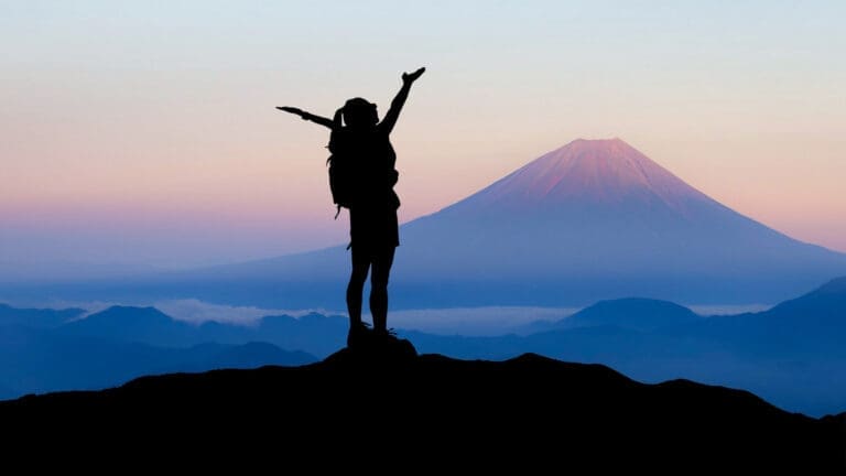 My Journey: silhouette of a joyful traveler with arms raised, standing on a mountaintop at sunrise symbolizing transformation, clarity, and resilience through neuroscience-based coaching
