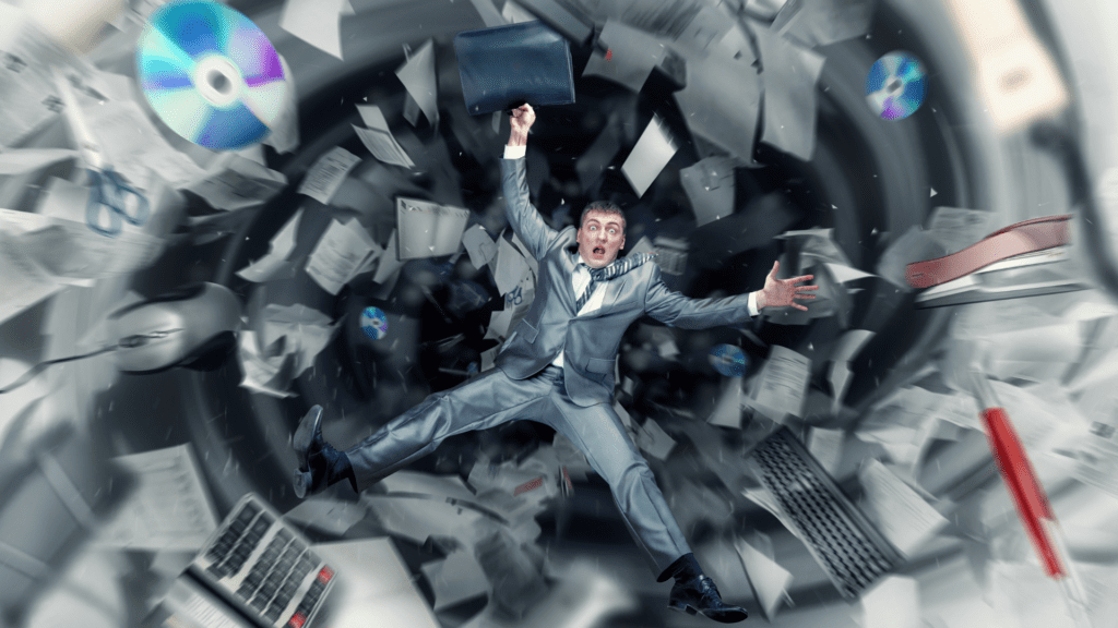 Businessman overwhelmed by swirling papers and digital tools, illustrating the chaos caused by distractions and the need for self-discipline.


