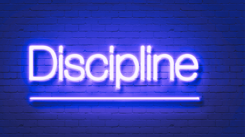 Neon sign displaying the word "Discipline" against a brick wall, symbolizing the structure and strength needed for achieving goals.


